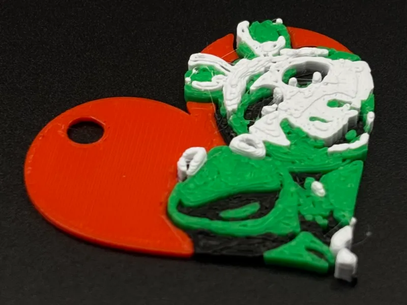 Heart-shaped keychain with Kermit and Miss Piggy silhouette